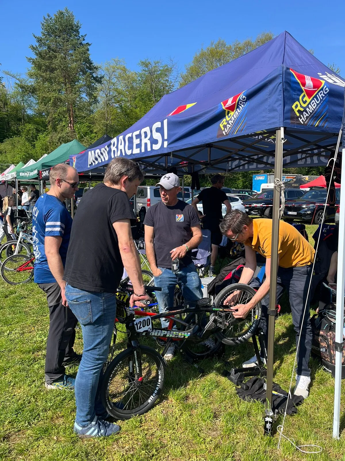 Team und Eltern schrauben unter dem RG Hamburg Zelt am BMX-Rad
