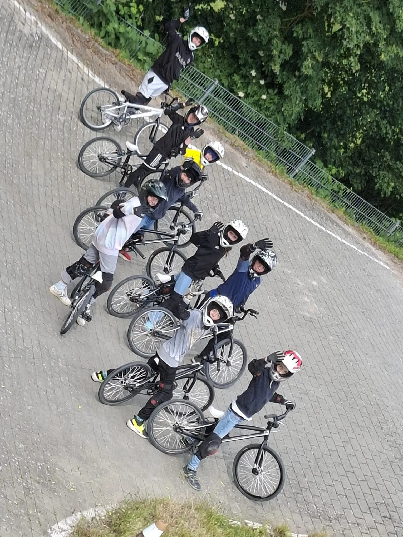 Luftaufnahme der jubelnden Kindergruppe mit ihren BMX-Rädern