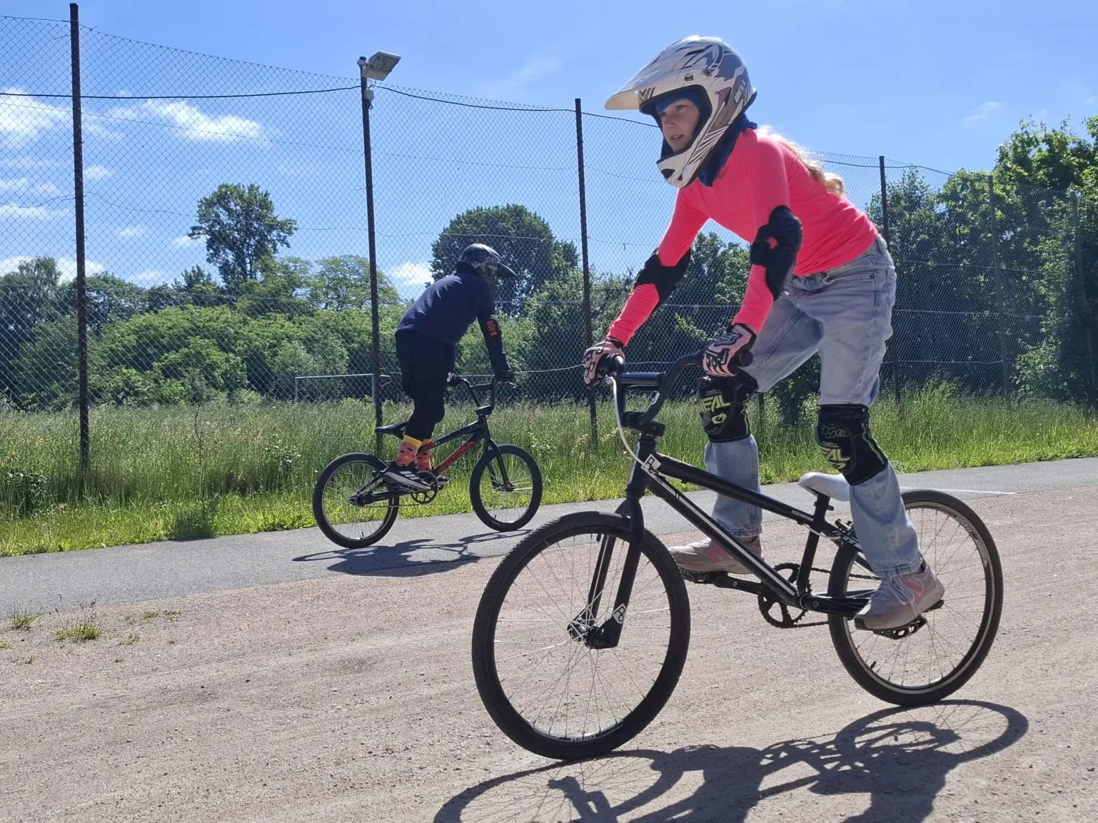 Junge Fahrerin meistert konzentriert eine Runde auf dem BMX-Track