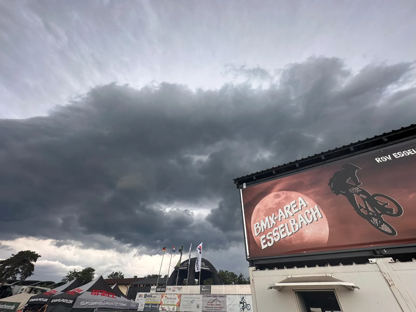 Dunkle Gewitterwolken über dem Banner der BMX-Area Esselbach